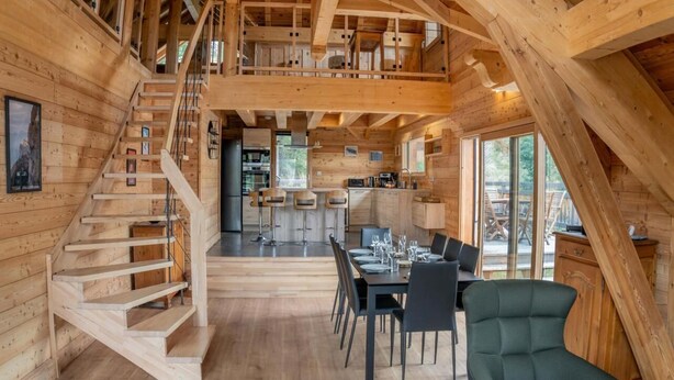 A wooden cabin interior with a staircase, dining area, kitchen, and large windows. - 350m from ski slopes, view mountain, balcony, tv, ski locker, 153m², Les Orres (Les Orres)
