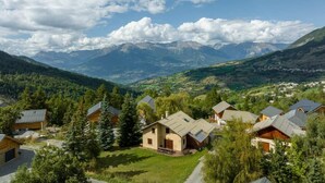 A mountain village with wooden houses, a clear sky, and distant mountains. - 350m from ski slopes, view mountain, balcony, tv, ski locker, 153m², Les Orres (Les Orres)