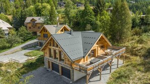 A wooden cabin with a deck, surrounded by forested hills. - 350m from ski slopes, view mountain, balcony, tv, ski locker, 153m², Les Orres (Les Orres)