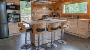 A modern kitchen with a central island, bar stools, stainless steel appliances, and wooden cabinetry. - 350m from ski slopes, view mountain, balcony, tv, ski locker, 153m², Les Orres (Les Orres)