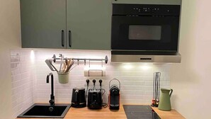 A compact kitchen with a sink, countertop, and cabinets.