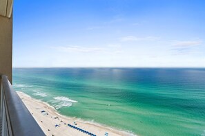 Uma praia com águas turquesa cristalinas e vista para o oceano a partir de uma varanda.
