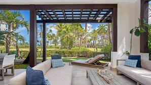 Un espacio de estar al aire libre cubierto, con vistas a un jardín ajardinado.