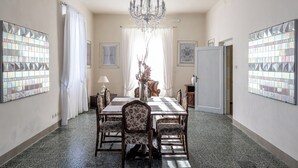 A dining room with a chandelier, floral chairs, and a table.