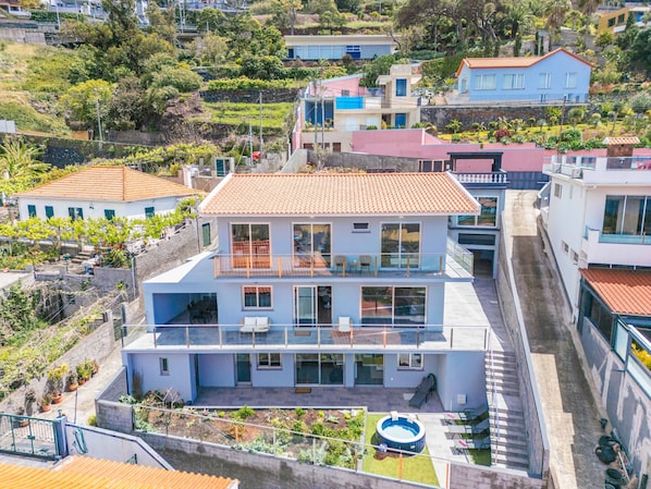 A multi-story residential building with a balcony, a swimming pool, and a garden area. - Villa Vellure by Madeira Sun Travel (Funchal)