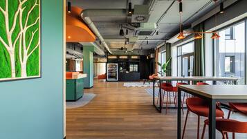 Een modern interieur met een houten vloer, een receptiebalie en oranje stoelen.
