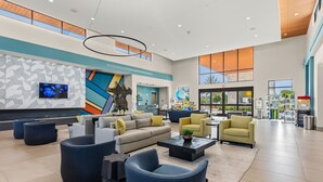 A spacious lobby with modern furniture, a large TV, and a view of the outdoors.