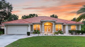 A single-story house with a red-tiled roof, a garage, and a well-maintained lawn. - Villa Corthouts: Luxury home close to bike trail! (Inverness)