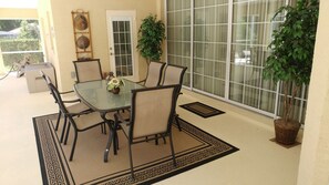 Relax in this serene patio area with a glass-top table and six comfortable chairs.