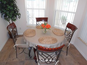 Enjoy meals in this cozy dining area with a round table for four, set with a tablecloth and placemats.