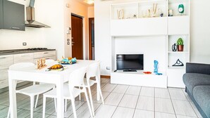A modern kitchen with white cabinetry, a built-in stove, and a stainless steel range hood.