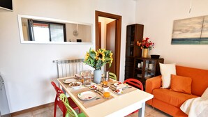 Un comedor con una mesa lista para el desayuno, un sofá y una estantería.