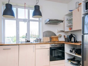 A kitchen with a double sink, a stove, and a refrigerator. - 4 Person Holiday Home in Skaerbaek (Skaerbaek)