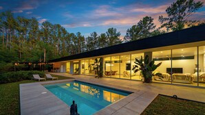 A modern house with a swimming pool, large windows, and a well-maintained lawn. - Floral City Oasis / Pool, BBQ Area & Forest View (Floral City)