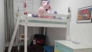 Une chambre d’enfant avec un lit superposé, un bureau et une chaise.