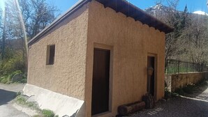 A small, single-story building with a simple, rustic design, featuring a single door and a small window. - Nice studio in the heart of Le Monêtier-les-Bains (Le Monêtier-les-Bains)