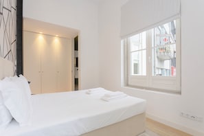 A bedroom with a bed, white curtains, a window, and a wardrobe. - Crystal Luxury Apartment  (Porto)