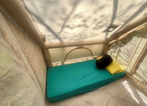 A small, enclosed sleeping area with a teal mattress and a black pillow. - 5 Minutes To Beach & Downtown - Safari Tent for Two (South Haven)
