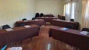 Une salle de conférence équipée de plusieurs tables, de chaises et d’un coin café.