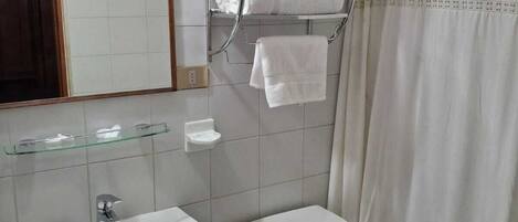 Une salle de bain équipée d’un lavabo, de toilettes et d’un porte-serviettes avec des serviettes.