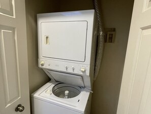 Een compacte, witte wasmachine met voorlader, een bedieningspaneel en een kleine, ronde trommel.