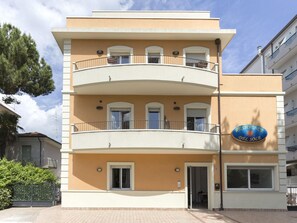 Ένα πολυώροφο ξενοδοχείο με μπεζ πρόσοψη, μπαλκόνια και μια επιγραφή που γράφει «Residence Del Sole».
