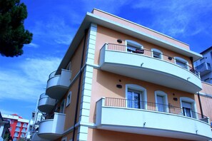 A multi-story building with balconies, a flat roof, and a clear blue sky. - Residence Del Sole (Rimini)