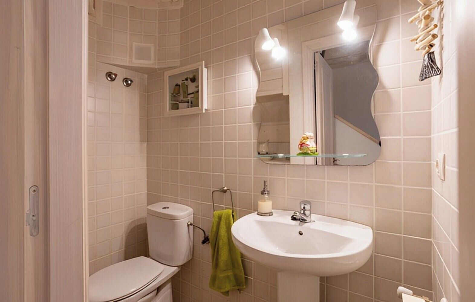 A bathroom with a toilet, sink, and mirror.