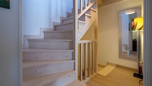 A wooden staircase leading to a landing with a mirror and a lamp. - Villa in Arredondo.  Arredondo between rivers and mountains, 20 minutes from the beaches. (Arredondo)