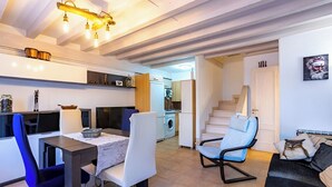 A modern living room with a dining area, a staircase, and a kitchen in the background. - Villa in Arredondo.  Arredondo between rivers and mountains, 20 minutes from the beaches. (Arredondo)