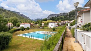 A residential area with a swimming pool, houses with red-tiled roofs, and a mountainous backdrop. - Villa in Arredondo.  Arredondo between rivers and mountains, 20 minutes from the beaches. (Arredondo)