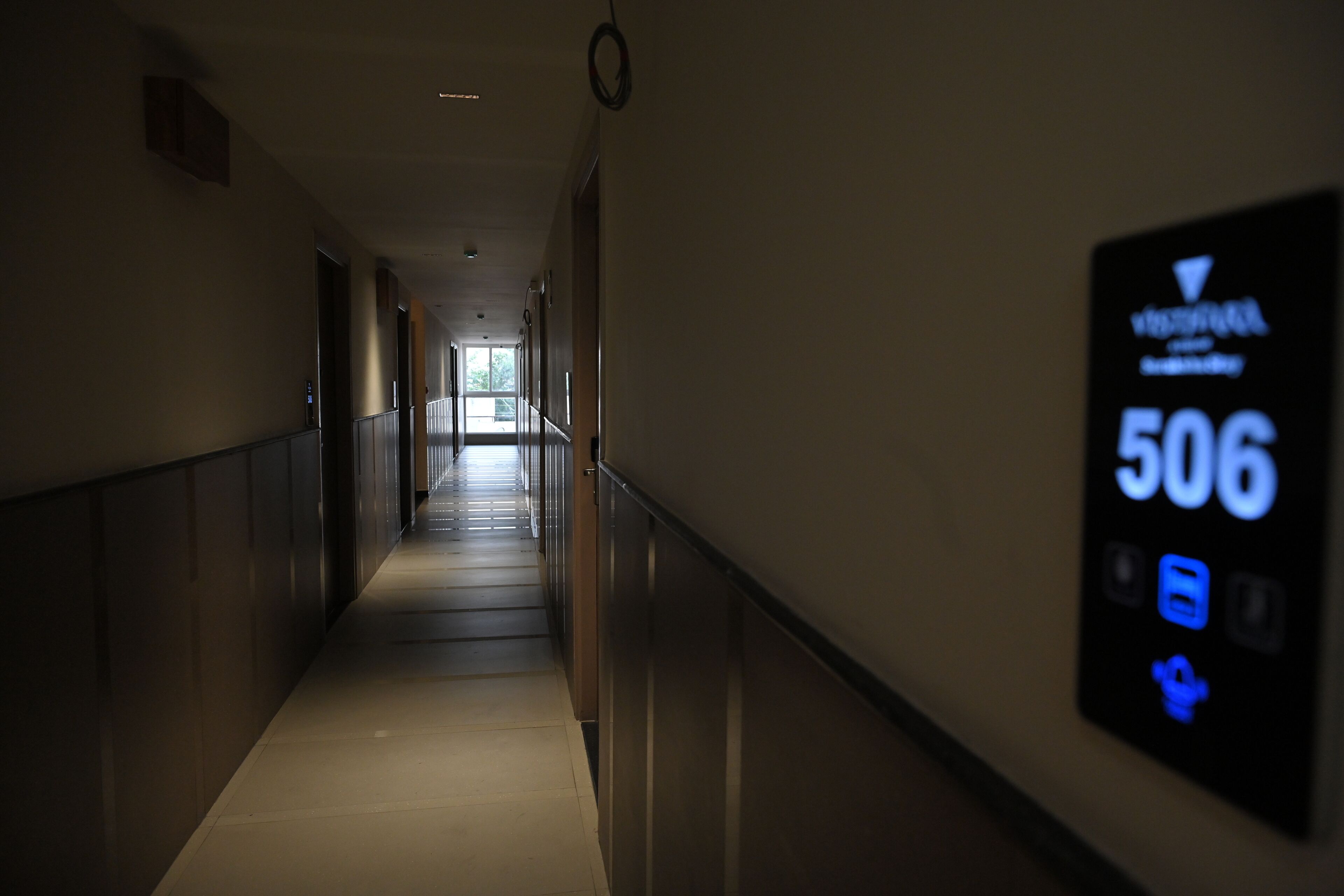 A hallway with a digital sign displaying room number 506.