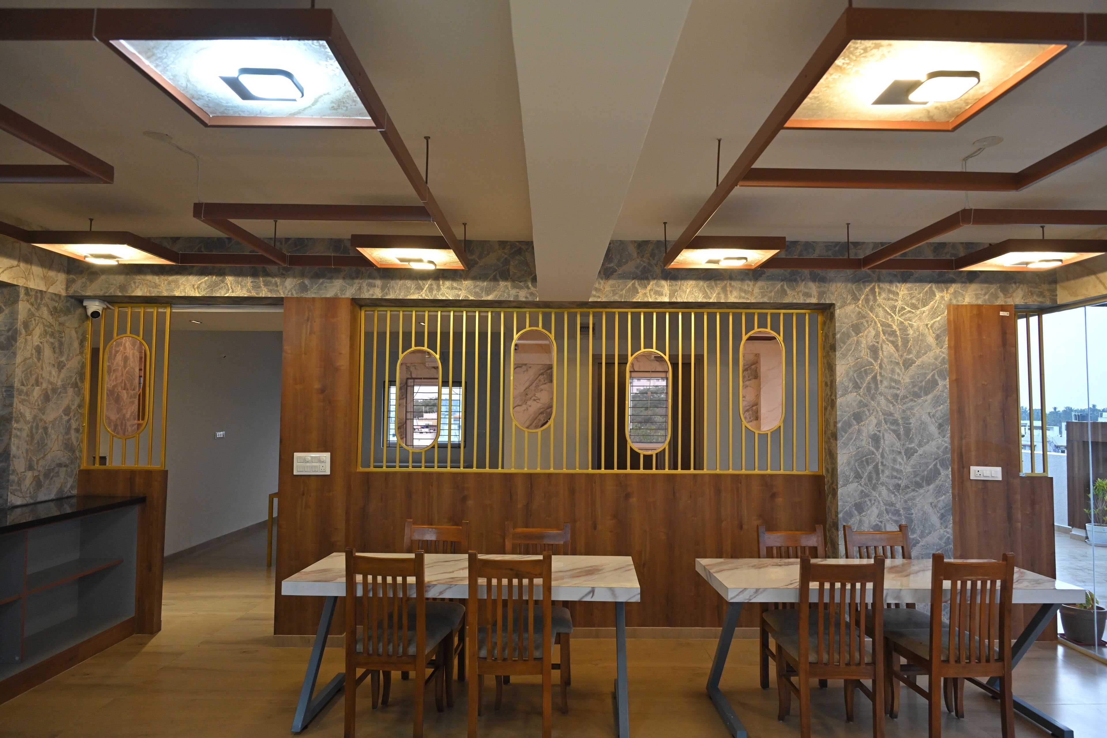 A restaurant with wooden paneling, marble-topped tables, and a stone wall.