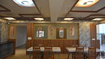Ein Restaurant mit Holzwandverkleidung, Marmortischen und einer Steinwand.