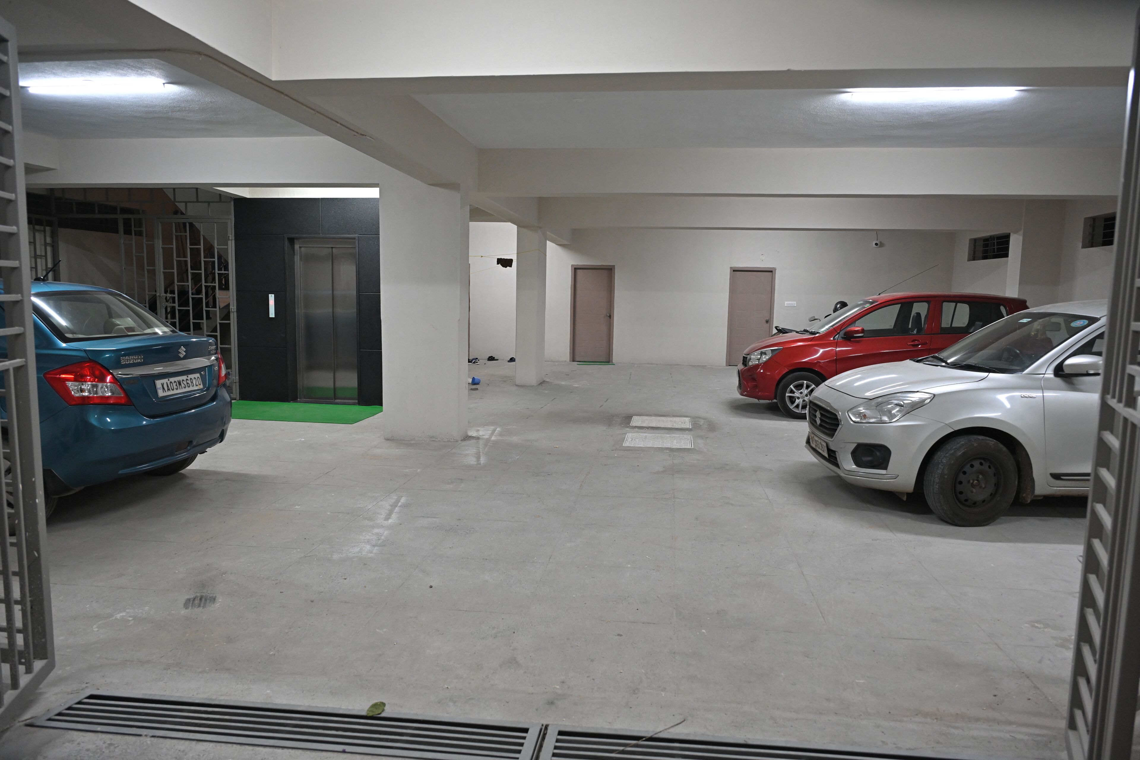 Un aparcamiento con tres coches estacionados uno tras otro.