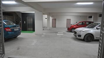 Un aparcamiento con tres coches estacionados uno tras otro.