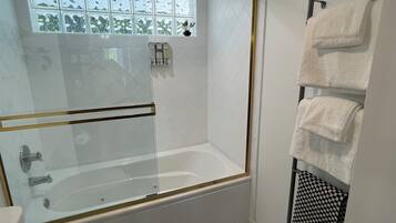 Une salle de bain moderne avec une douche à parois de verre, une baignoire et des toilettes.
