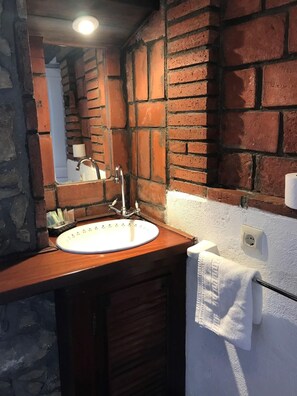 A bathroom with a white sink, a mirror, and a towel rack. - Hotel Palacio De Libardon (Colunga)
