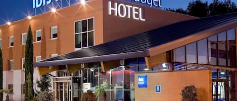 Un hotel con diseño moderno, que destaca un cartel con la leyenda "ibis budget HOTEL".