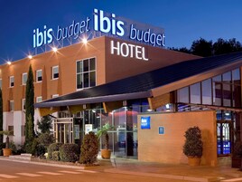 A hotel with a modern design, featuring a prominent sign that reads "ibis budget HOTEL."