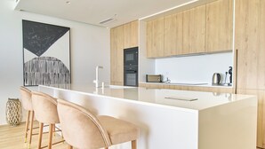 A modern kitchen with a large island, wooden cabinets, and a minimalist design.