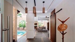 A modern hotel corridor with a pool view, a sofa, and a hat rack. - WAYAK Luxury! 5BR Private Pool & Gym, 24/7Security (Tulum)