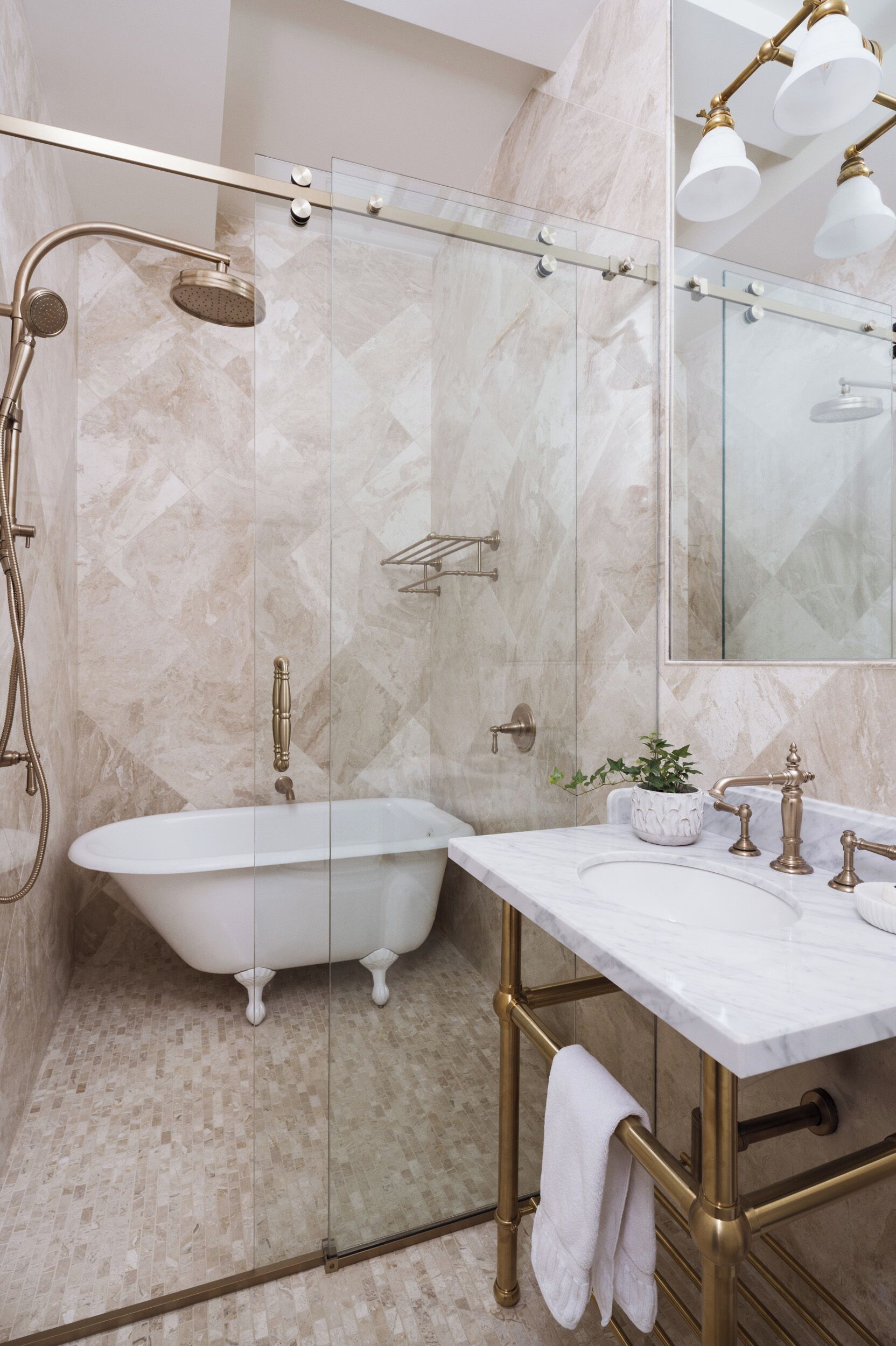 Un baño con bañera independiente, tocador con espejo y cabina de ducha con puertas de vidrio.