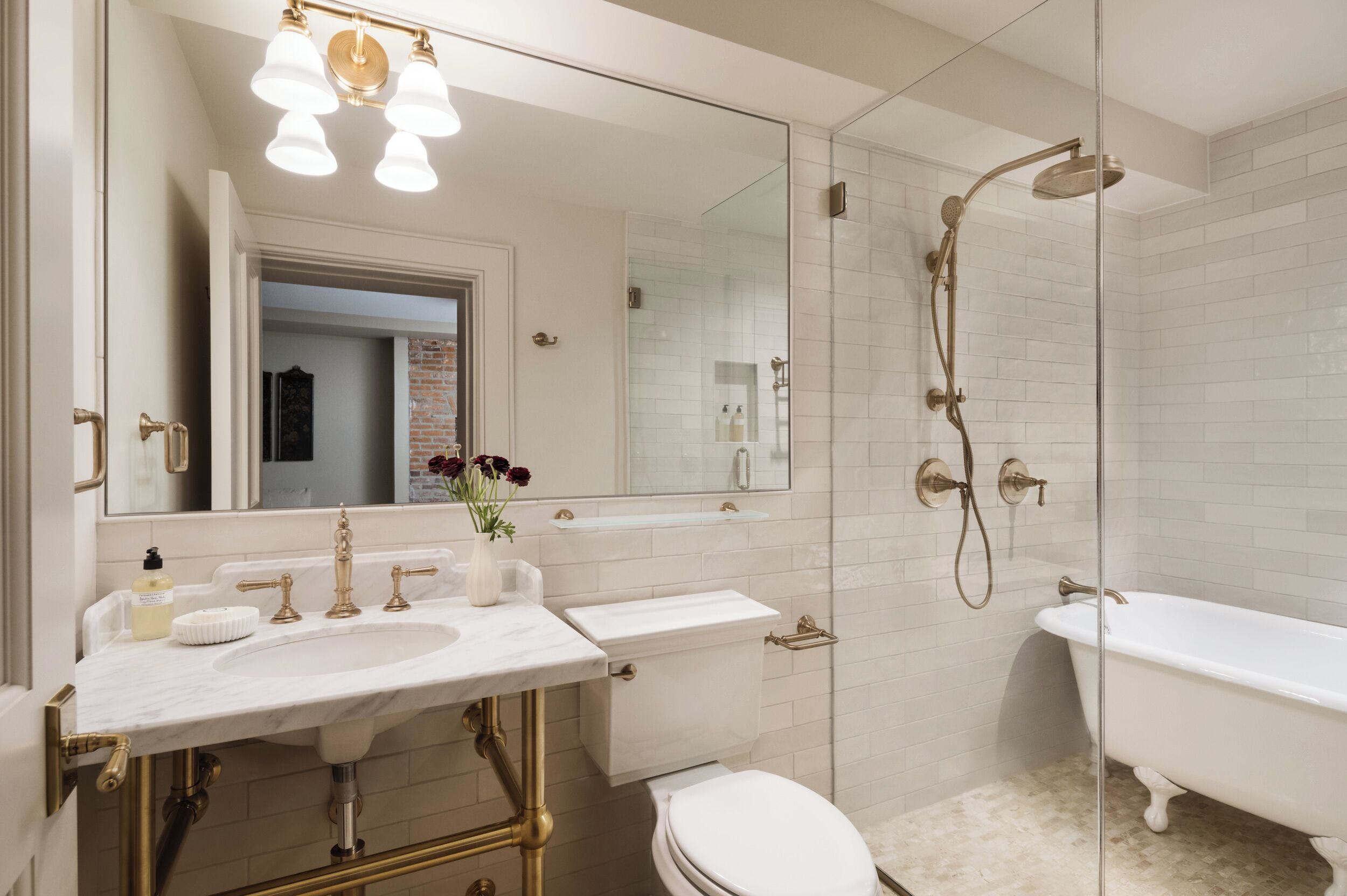 A bathroom with a white sink, a toilet, a bathtub, and a glass-enclosed shower area.