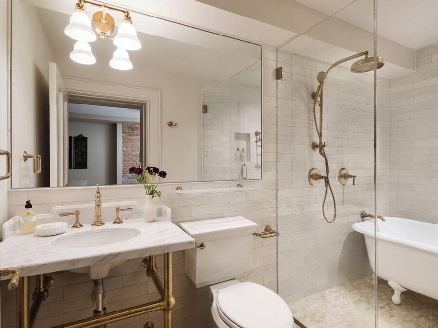 A bathroom with a white sink, a toilet, a bathtub, and a glass-enclosed shower area.