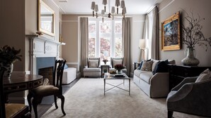Una sala de estar con chimenea, un candelabro y un sofá.