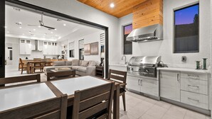 A modern kitchen with white cabinets, a built-in stove, and a large window. - LUXE: Custom Beach Home w/Pool&Spa, Fire Pit, BBQ (Naples)