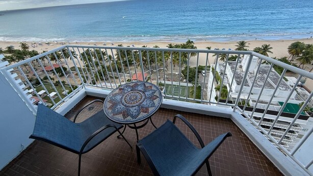 Un balcón con vista a la playa y el océano.