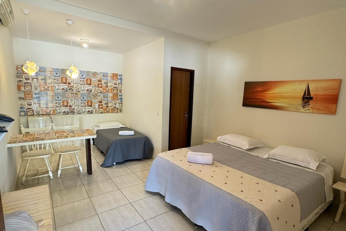 Une chambre d’hôtel avec un lit, un bureau, une chaise et un mur orné d’un tableau.