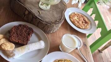 Uma mesa de madeira com um prato de comida, um copo de leite e um garfo.